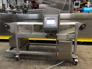 Metal detector conveyor pada jalur pemeriksaan produk makanan dalam kemasan