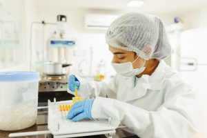 Peneliti menimbang sampel kecil pada microbalance laboratorium